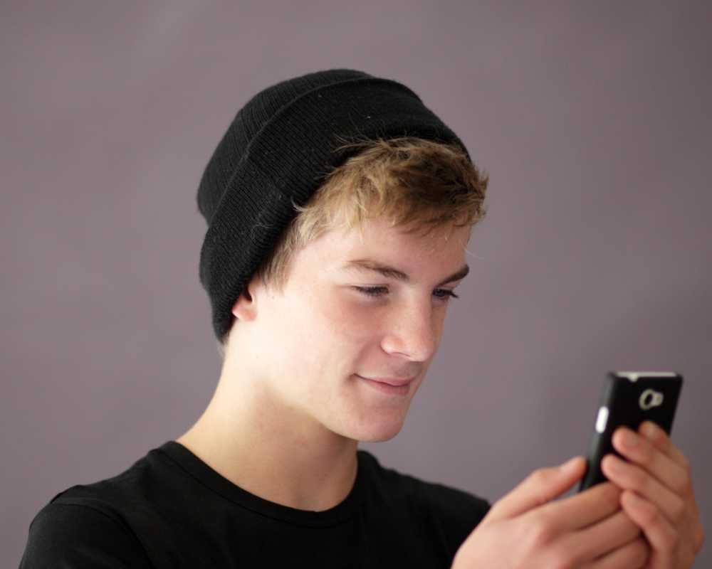 Adolescente mirando su teléfono celular